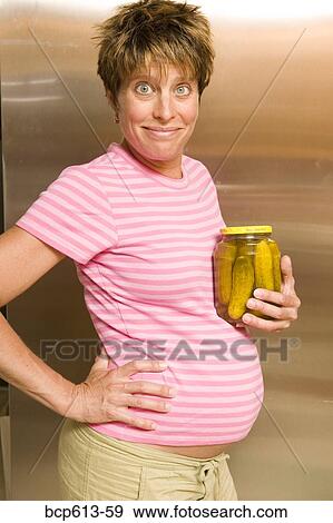 Stock Photo - Portrait of pregnant woman with pickles. Fotosearch