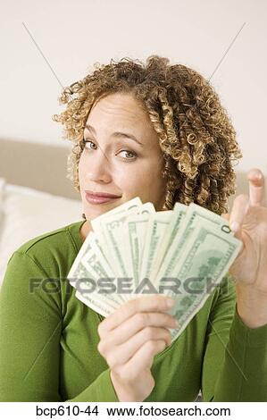 Picture - Portrait of woman with handful of money. Fotosearch