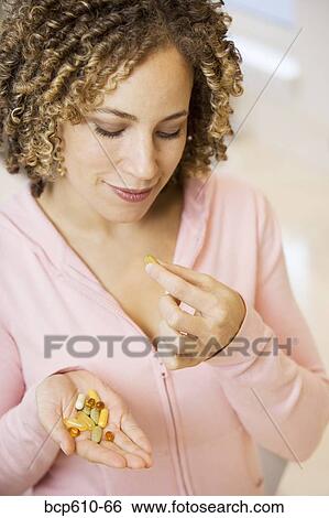 Portrait of woman with handful of pills View Large Photo Image Stock Photograph - Portrait of woman with handful of pills. Fotosearch