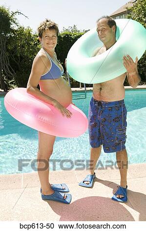 Pregnant couple at pool with inner tubes View Large Photo Image Stock Image - Pregnant couple at pool with inner tubes. Fotosearch