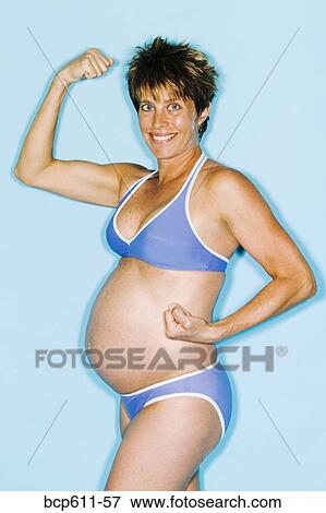 Pregnant woman in bikini showing muscles View Large Photo Image Stock Photo - Pregnant woman in bikini showing muscles. Fotosearch