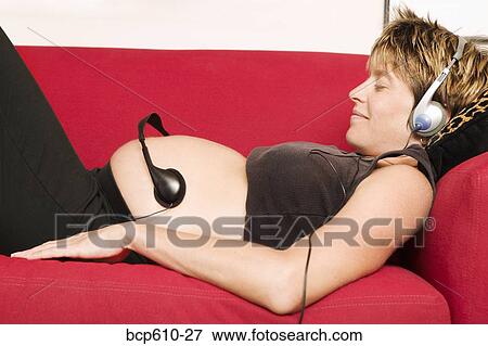 Pregnant woman with headphones on belly View Large Photo Image Stock Photo - Pregnant woman with headphones on belly. Fotosearch