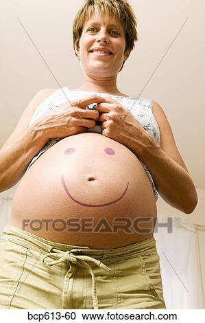 Pregnant woman with smiley face on belly View Large Photo Image Stock Image - Pregnant woman with smiley face on belly. Fotosearch