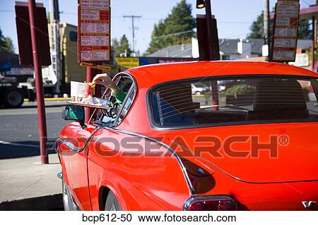 Reaching through sports car window at drive-in View Large Photo Image Stock Image - Reaching through sports car window at drive-in. Fotosearch