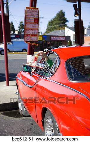 Reaching through sports car window at drive-in View Large Photo Image Stock Image - Reaching through sports car window at drive-in. Fotosearch