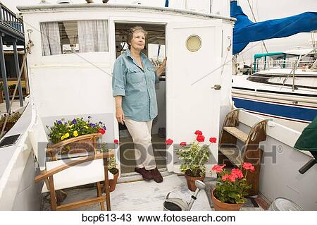 Stock Image - Reflective woman on houseboat. Fotosearch