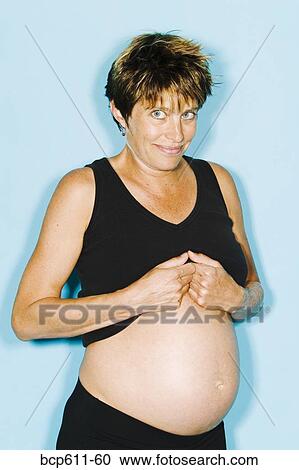 Shy pregnant woman showing her belly View Large Photo Image Stock Image - Shy pregnant woman showing her belly. Fotosearch