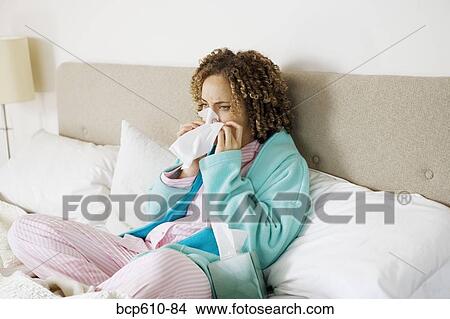 Sick woman in bed blowing her nose View Large Photo Image Picture - Sick woman in bed blowing her nose. Fotosearch