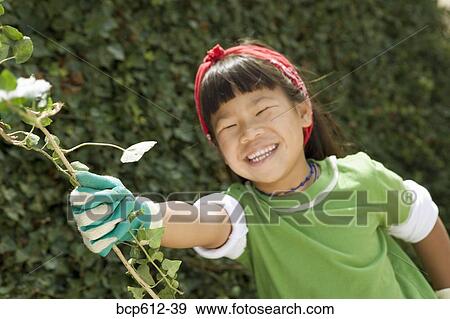 Stock Photo - Smiling girl wearing gardening gloves. Fotosearch