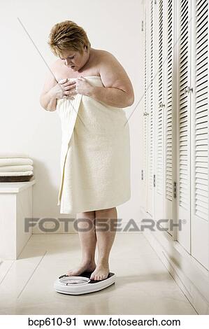 Upset overweight woman on bathroom scale View Large Photo Image Stock Image - Upset overweight woman on bathroom scale. Fotosearch