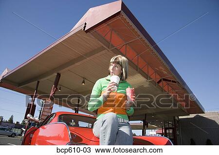 Woman eating at drive-in restaurant View Large Photo Image Stock Image - Woman eating at drive-in restaurant. Fotosearch