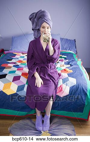 Picture - Woman in bathrobe drinking water. Fotosearch