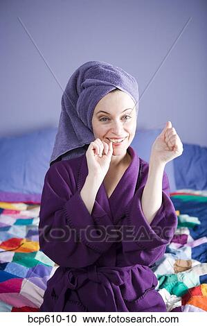 Woman in bathrobe flossing on bed View Large Photo Image Stock Image - Woman in bathrobe flossing on bed. Fotosearch