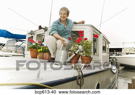 Woman on houseboat with plants View Large Photo Image Stock Image - Woman on houseboat with plants. Fotosearch