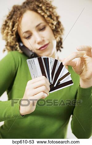 Woman on phone choosing credit card View Large Photo Image Stock Image - Woman on phone choosing credit card. Fotosearch