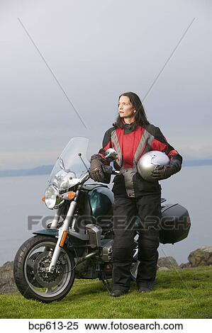 Stock Photography - Woman posing with motorcycle. Fotosearch