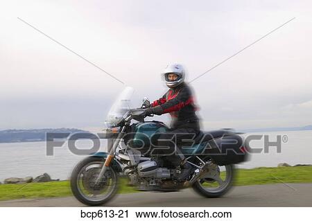 Woman riding motorcycle on coastal road View Large Photo Image Stock Image - Woman riding motorcycle on coastal road. Fotosearch