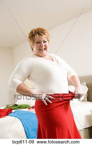 Woman showing off weight loss with waistband View Large Photo Image Stock Photo - Woman showing off weight loss with waistband. Fotosearch