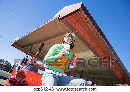 Woman with fries and beverage at drive-in View Large Photo Image Stock Photograph - Woman with fries and beverage at drive-in. Fotosearch
