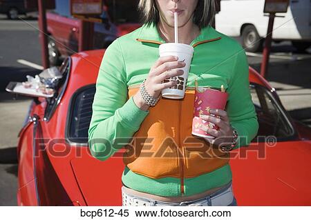 Woman with fries and beverage at drive-in View Large Photo Image Stock Photography - Woman with fries and beverage at drive-in. Fotosearch
