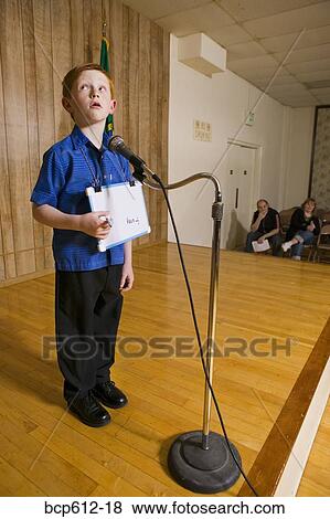 Stock Photo - Young boy on stage with microphone. Fotosearch
