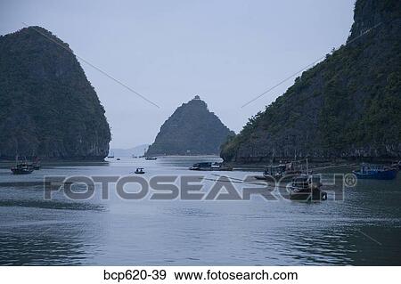Boats and islands at dusk on Vietnamese bay View Large Photo Image Stock Photo - Boats and islands at dusk on Vietnamese bay. Fotosearch
