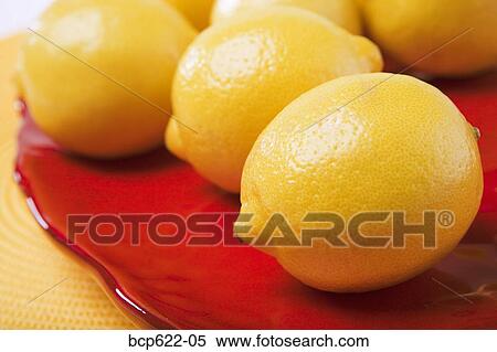 Closeup of lemons on red platter View Large Photo Image Stock Photography - Closeup of lemons on red platter. Fotosearch