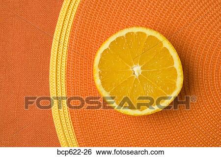 Stock Photograph - Closeup of orange slice on placemat. Fotosearch