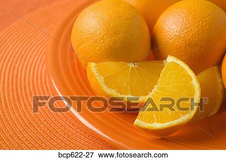 Closeup of oranges and orange slices on plate View Large Photo Image Stock Photo - Closeup of oranges and orange slices on plate. Fotosearch