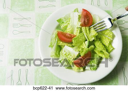 Stock Image - Closeup of salad with fork. Fotosearch