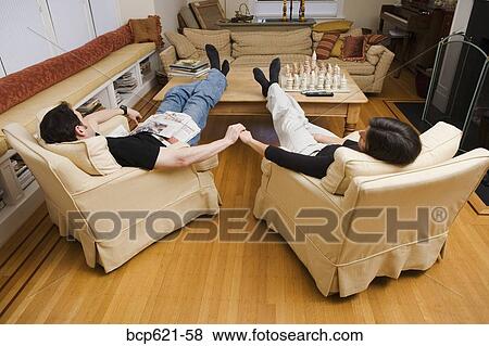 Couple relaxing at home in living room View Large Photo Image Stock Photo - Couple relaxing at home in living room. Fotosearch