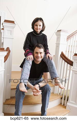 Daughter sitting on dads shoulders on stairs View Large Photo Image Stock Photography - Daughter sitting on dads shoulders on stairs. Fotosearch