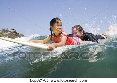 Father and daughter paddling surfboard View Large Photo Image Stock Photography - Father and daughter paddling surfboard. Fotosearch