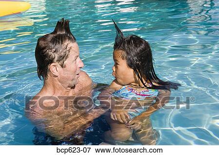 Stock Photo - Father and daughter with silly hairdos in pool. Fotosearch