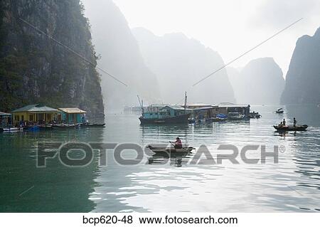Floating Vietnamese fishing village with rocky coastline View Large Photo Image Stock Photo - Floating Vietnamese fishing village with rocky coastline. Fotosearch