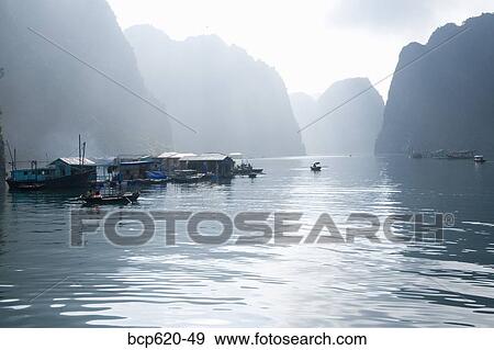 Floating Vietnamese fishing village with rocky coastline View Large Photo Image Stock Photo - Floating Vietnamese fishing village with rocky coastline. Fotosearch