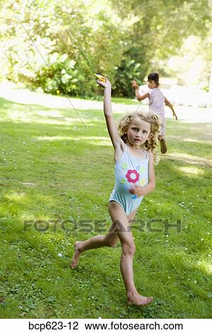 Girl in bathing suit flying kite View Large Photo Image Stock Image - Girl in bathing suit flying kite. Fotosearch