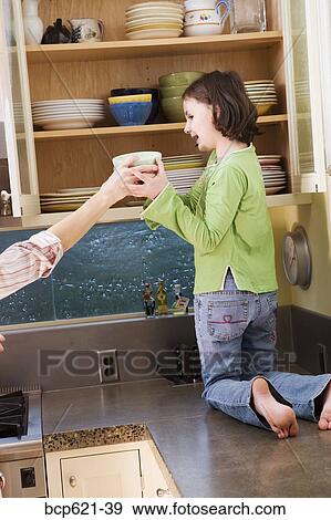 Girl kneeling on kitchen counter with dishes View Large Photo Image Stock Photo - Girl kneeling on kitchen counter with dishes. Fotosearch