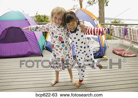 Stock Image - Girls in pajamas with tents on balcony. Fotosearch