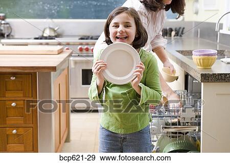 Laughing daughter unloading dishwasher with mother View Large Photo Image Stock Photo - Laughing daughter unloading dishwasher with mother. Fotosearch