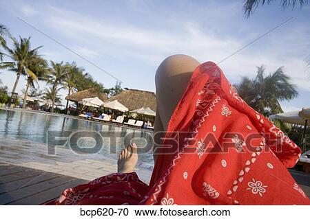 Legs of woman relaxing poolside at resort View Large Photo Image Stock Image - Legs of woman relaxing poolside at resort. Fotosearch