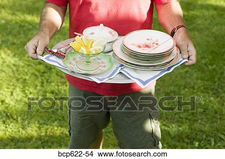 Man carrying tray of dishes outside View Large Photo Image Picture - Man carrying tray of dishes outside. Fotosearch