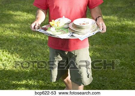 Man carrying tray of dishes outside View Large Photo Image Stock Image - Man carrying tray of dishes outside. Fotosearch