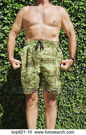 Man in swimming trunks flexing muscles View Large Photo Image Stock Image - Man in swimming trunks flexing muscles. Fotosearch