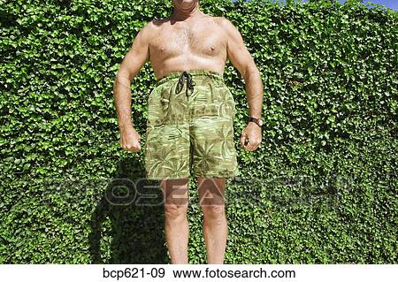 Man posing comically in swimming trunks View Large Photo Image Stock Photo - Man posing comically in swimming trunks. Fotosearch