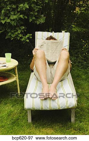 Man reading newspaper in his backyard View Large Photo Image Stock Photo - Man reading newspaper in his backyard. Fotosearch