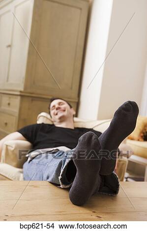 Man relaxing at home with feet up View Large Photo Image Picture - Man relaxing at home with feet up. Fotosearch