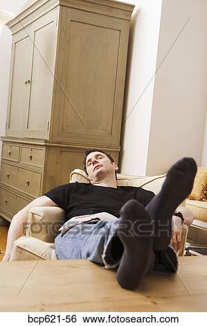 Man sleeping in chair with feet up View Large Photo Image Stock Photograph - Man sleeping in chair with feet up. Fotosearch