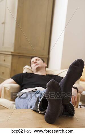 Man sleeping in chair with feet up View Large Photo Image Stock Photography - Man sleeping in chair with feet up. Fotosearch