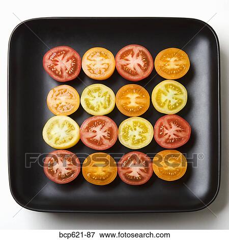 Stock Photo - Multicolored tomato slices in dish. Fotosearch